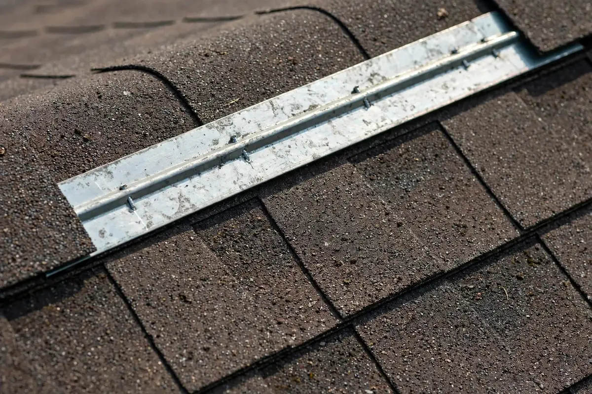 Zinc strip installed along the ridge of an asphalt shingle roof